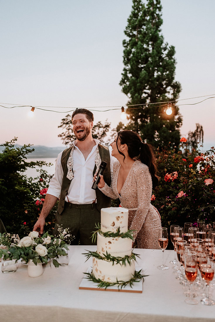 Los novios ríen plenamente felices momentos previos a cortar la torta de boda. Celebran su boda en Patagonia Argentina planificada por Dupla Planners.